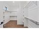 Bright walk-in closet with custom shelving and brown carpet at 5741 Doc Bar Circle, Larkspur, CO 80118