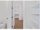 Bright walk-in closet with custom shelving and brown carpet at 5741 Doc Bar Circle, Larkspur, CO 80118
