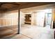 Unfinished basement featuring concrete floors, exposed drywall, storage shelves and a metal door to the outside at 2090 S Hannibal Way # C, Aurora, CO 80013