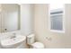 Clean bathroom with toilet, sink, and mirror at 13352 E 110Th Way, Commerce City, CO 80022