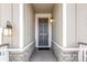 Front entry with gray door, stone accents, and light fixtures at 13352 E 110Th Way, Commerce City, CO 80022