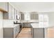 Modern kitchen with gray cabinets, large island, and white countertops at 13352 E 110Th Way, Commerce City, CO 80022