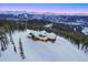 Aerial view of timber frame home with snowy landscape and majestic mountain backdrop at 250 Sallie Barber Rd, Breckenridge, CO 80424