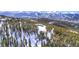 Aerial view of the residence nestled among snow-covered pine trees with the slopes in the background at 250 Sallie Barber Rd, Breckenridge, CO 80424