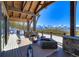 Covered deck with outdoor seating area and fireplace overlooking mountain views at 250 Sallie Barber Rd, Breckenridge, CO 80424