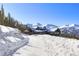 Exterior view of a mountain home covered in snow with ski slopes in the distance at 250 Sallie Barber Rd, Breckenridge, CO 80424