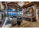 Open-concept living area with a stone fireplace, wood beams, vaulted ceilings, bar area, and mountain views at 250 Sallie Barber Rd, Breckenridge, CO 80424