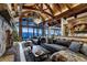 A living room with a stone fireplace, wooden beams, vaulted ceilings, bar area, and mountain views at 250 Sallie Barber Rd, Breckenridge, CO 80424