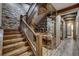 This staircase features a glass enclosed wine storage, stone walls and wooden banister at 250 Sallie Barber Rd, Breckenridge, CO 80424