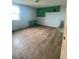 Basement room features a green accent wall and light wood floor at 47904 Dartmouth Ave, Bennett, CO 80102