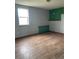 Basement room features a green accent wall and light wood floor at 47904 Dartmouth Ave, Bennett, CO 80102