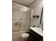 Bathroom features shower with glass door, toilet, and sink with cabinet at 47904 Dartmouth Ave, Bennett, CO 80102