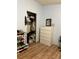 Bedroom with wood floors, open closet, and white dresser at 47904 Dartmouth Ave, Bennett, CO 80102