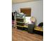 Bedroom with wood floors, closet with hanging clothes, and items stored in plastic tubs at 47904 Dartmouth Ave, Bennett, CO 80102