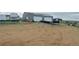 Outbuilding/garage with two rollup doors and a flatbed trailer outside on a large dirt lot at 47904 Dartmouth Ave, Bennett, CO 80102