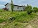 Exterior of a gray home surrounded by grassy land and foliage at 47904 Dartmouth Ave, Bennett, CO 80102