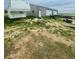 Vacant land with dirt and sparse green grass, featuring a large building and a trailer at 47904 Dartmouth Ave, Bennett, CO 80102