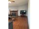 Comfortable living room showcasing a fireplace, wood floors, and a TV, perfect for relaxing at 47904 Dartmouth Ave, Bennett, CO 80102