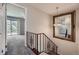 Hallway featuring wrought iron stair railing and a large mirror at 6727 S Race St, Centennial, CO 80122