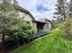 Backyard with a stone patio and lush lawn, surrounded by mature trees and greenery at 6875 Northstar Ct, Castle Rock, CO 80108