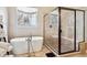 Bright bathroom featuring a freestanding tub and a glass enclosed shower with pebble floor and bench seat at 6875 Northstar Ct, Castle Rock, CO 80108