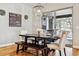 An elegant dining room features a rustic table and a chandelier over it, with natural light from a sliding glass door at 6875 Northstar Ct, Castle Rock, CO 80108