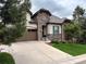 A beautiful home showcasing stone accents, a well-maintained lawn, and a spacious driveway leading to a two-car garage at 6875 Northstar Ct, Castle Rock, CO 80108