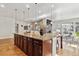 Expansive kitchen island with granite countertop and dark wood cabinets, seamlessly connecting to the living and dining areas at 6875 Northstar Ct, Castle Rock, CO 80108