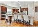 Well-lit kitchen with dark wood cabinets, stainless steel appliances, granite countertops, and a breakfast bar with seating at 6875 Northstar Ct, Castle Rock, CO 80108