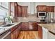 A gourmet kitchen featuring granite countertops, stainless steel appliances, a stylish backsplash, and hardwood floors at 6875 Northstar Ct, Castle Rock, CO 80108