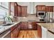 Modern kitchen with dark wood cabinets, granite countertops, tile backsplash, stainless steel appliances and hardwood floors at 6875 Northstar Ct, Castle Rock, CO 80108