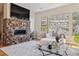 Comfortable living room boasts a stone fireplace, neutral decor, and large windows with rock outcropping views at 6875 Northstar Ct, Castle Rock, CO 80108