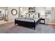 Carpeted main bedroom showcasing a stylish black bed frame and bedside tables, complemented by a ceiling fan at 6875 Northstar Ct, Castle Rock, CO 80108