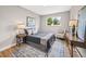 Comfortable bedroom with hardwood floors, a large window, and a chair and desk for work at 9120 W 3Rd Pl, Lakewood, CO 80226
