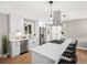 Bright kitchen featuring stainless steel appliances, white cabinets, and an island with seating at 9120 W 3Rd Pl, Lakewood, CO 80226