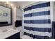 Bathroom features a blue and white striped shower curtain and navy blue vanity at 8881 Judson St, Westminster, CO 80031
