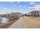 Scenic view of a home near a tranquil lake and a paved walkway, perfect for outdoor enjoyment at 9118 W 50Th Ln # 5, Arvada, CO 80002