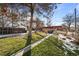 Large backyard with mature trees, grassy area, and garden beds at 1585 Roslyn St, Denver, CO 80220