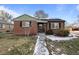 Nice brick ranch home with a green roofline, solar panels, and a grassy yard at 1585 Roslyn St, Denver, CO 80220