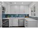 Updated kitchen, white cabinets, blue tile backsplash, stainless steel appliances at 1585 Roslyn St, Denver, CO 80220