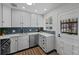 Modern kitchen with white cabinets, blue tile backsplash and stainless steel appliances at 1585 Roslyn St, Denver, CO 80220