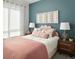 Bright bedroom features stylish decor with a decorative headboard, lamps, and pretty wall art at 6153 N Ceylon St # 102, Denver, CO 80249