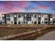 Modern apartment building with black and white facade, featuring balconies and a landscaped front at 6153 N Ceylon St # 102, Denver, CO 80249