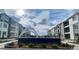 A modern apartment community sign featuring gray buildings and beautiful landscaping on a sunny day at 6153 N Ceylon St # 102, Denver, CO 80249
