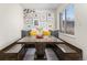 Charming dining area featuring a large window, unique wall art, and custom benches with built-in storage at 3761 W Saratoga Ave, Littleton, CO 80123