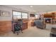 Finished basement featuring wood paneling, a cozy fireplace, and office setup with a computer at 9590 W Eureka Pl, Lakewood, CO 80227