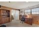Finished basement with wood paneling, built-in shelves, and office space with a computer setup at 9590 W Eureka Pl, Lakewood, CO 80227