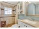 Updated bathroom featuring tiled shower with bench, white vanity, and medicine cabinet at 9590 W Eureka Pl, Lakewood, CO 80227