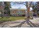 Two-story home featuring a manicured lawn, mature trees, and a covered entrance leading to the front door at 9590 W Eureka Pl, Lakewood, CO 80227