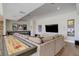 A finished basement with a long shuffleboard table, comfortable seating, and a large TV at 13176 Frannys Way, Parker, CO 80138